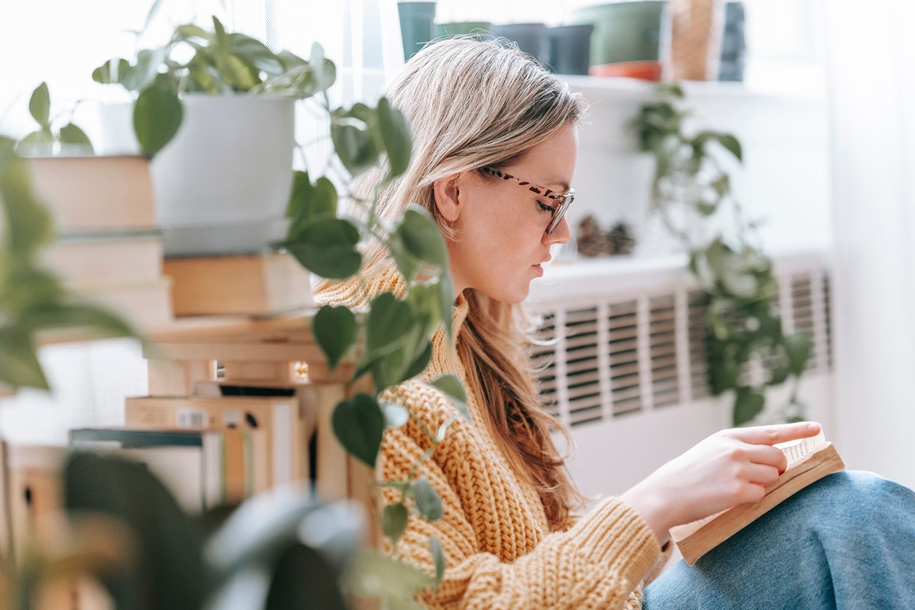 concentrated young woman reading interesting book on floor at home